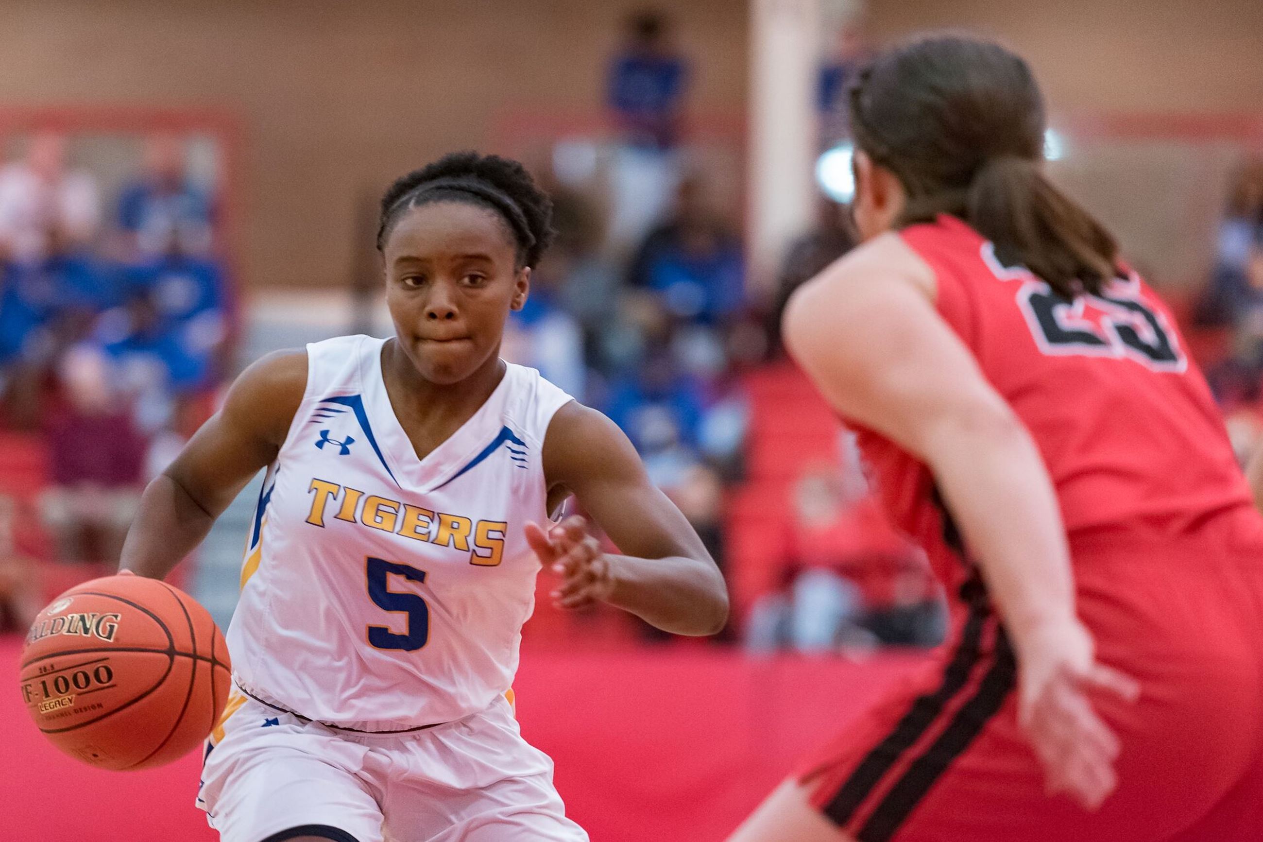 Female basketball player dribbling ball down the court